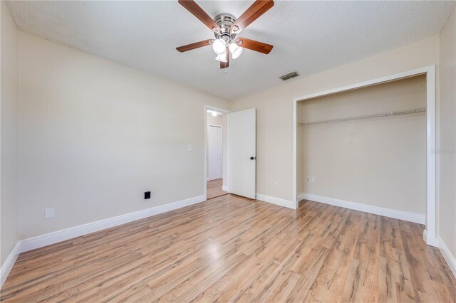 unfurnished bedroom with visible vents, a textured ceiling, a closet, light wood-style floors, and baseboards