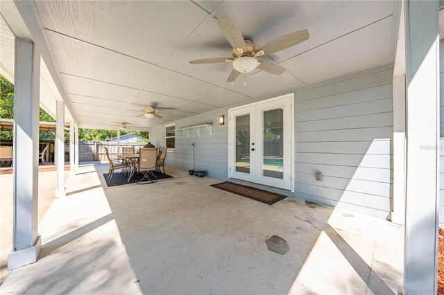 view of patio featuring ceiling fan, french doors, outdoor dining space, and fence