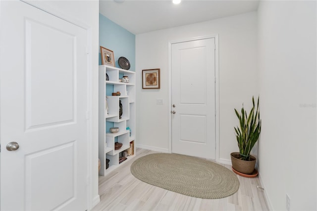 entryway featuring baseboards and wood finished floors