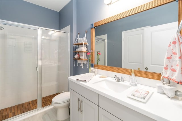 full bath with vanity, a shower stall, and toilet