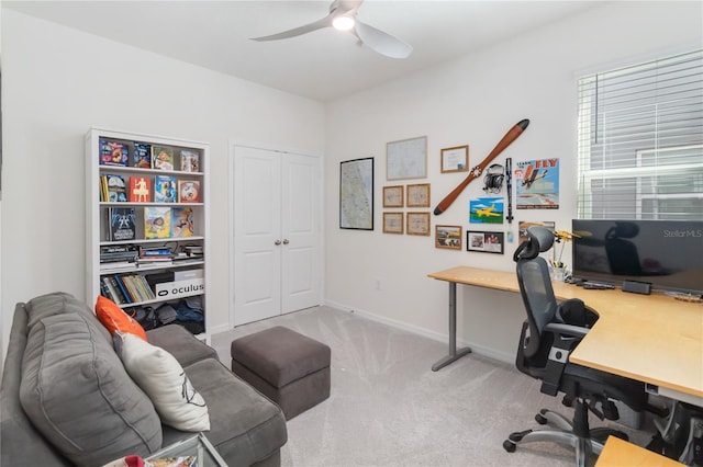 office space with baseboards, carpet floors, and a ceiling fan