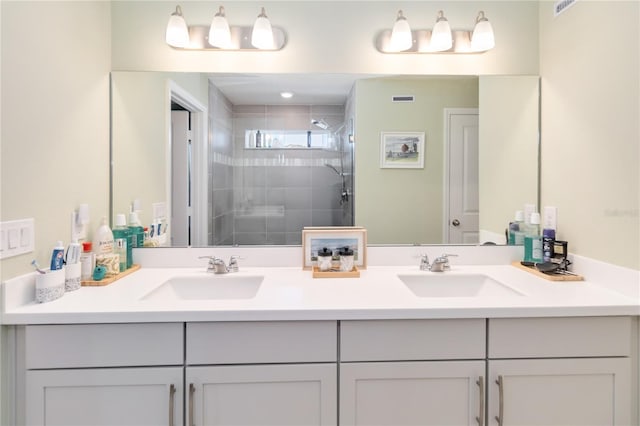 full bathroom with double vanity, a shower stall, and a sink