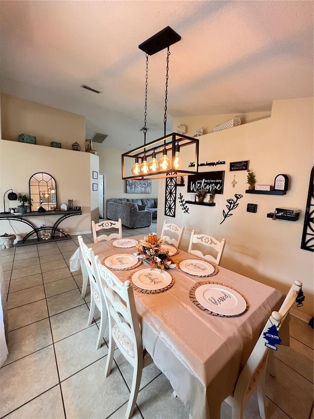 dining space featuring light tile patterned floors and lofted ceiling