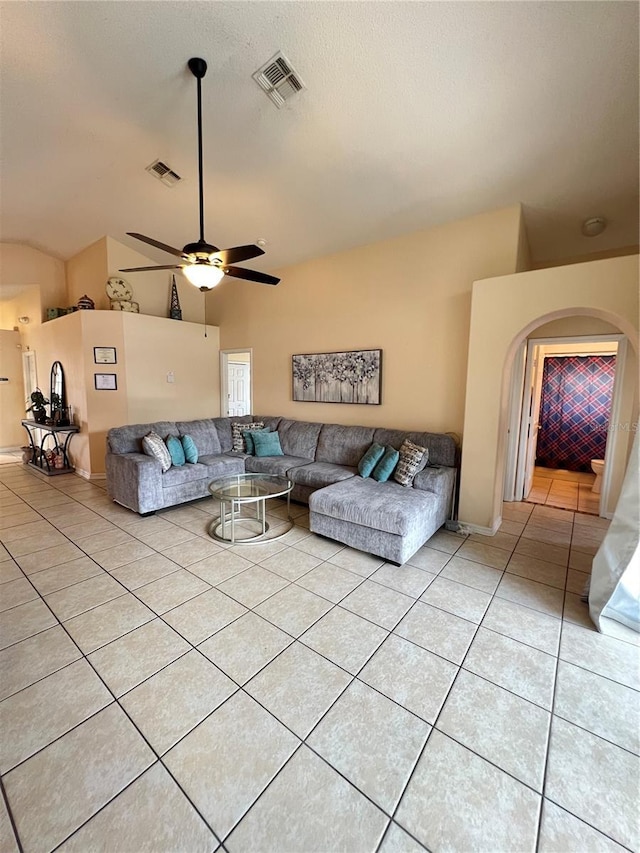 living area featuring light tile patterned floors, visible vents, ceiling fan, and lofted ceiling