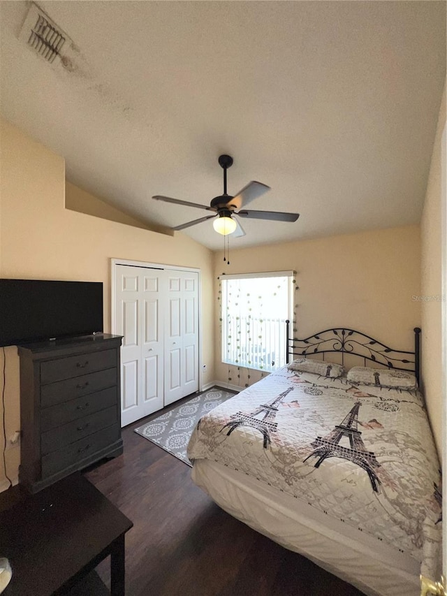 bedroom featuring visible vents, lofted ceiling, wood finished floors, a closet, and a ceiling fan