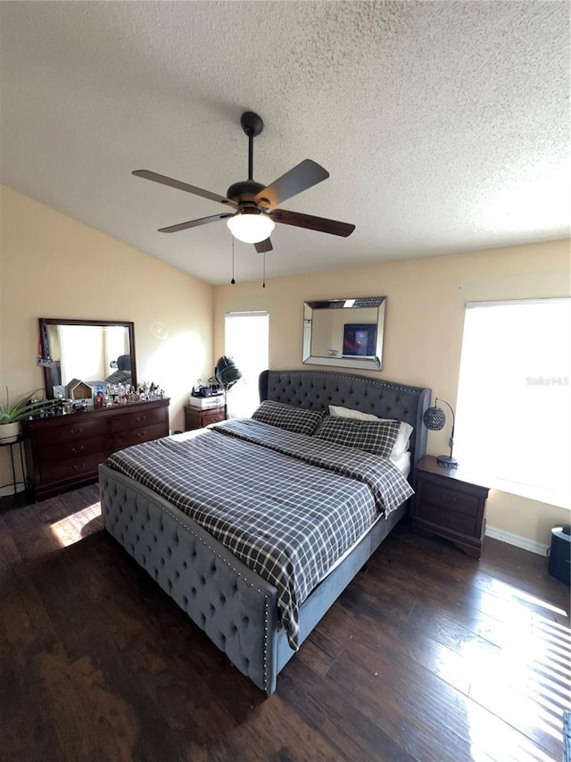 bedroom featuring a ceiling fan, lofted ceiling, wood finished floors, and a textured ceiling