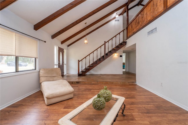 unfurnished living room featuring visible vents, high vaulted ceiling, wood finished floors, and stairs