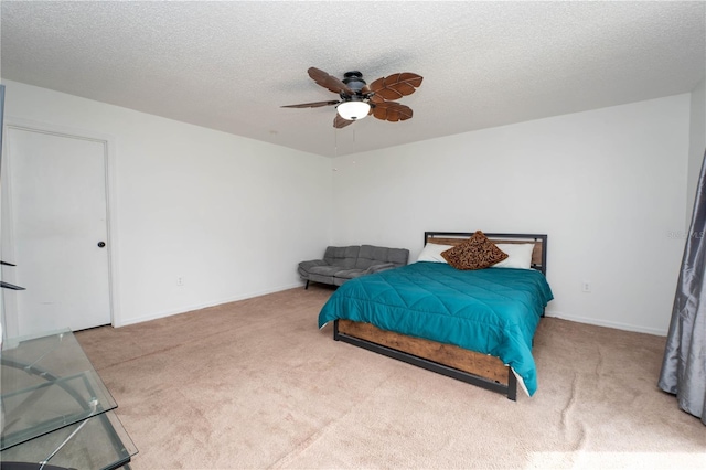 bedroom with ceiling fan, a textured ceiling, baseboards, and carpet floors