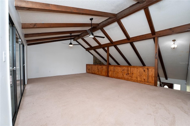 interior space featuring lofted ceiling with beams, carpet floors, and ceiling fan