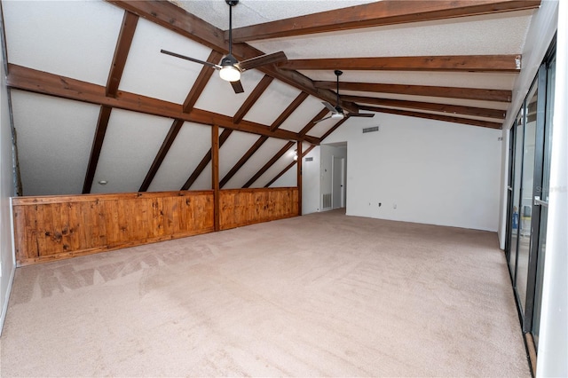 unfurnished living room featuring vaulted ceiling with beams, light colored carpet, visible vents, and ceiling fan