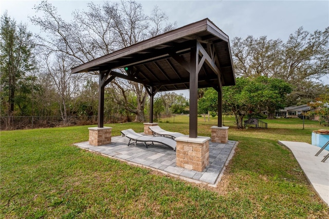 exterior space featuring a gazebo, a lawn, a patio, and fence