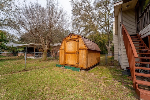 view of shed with stairs and a fenced backyard