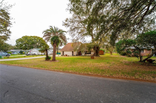 view of front of property featuring driveway, a front lawn, and a garage