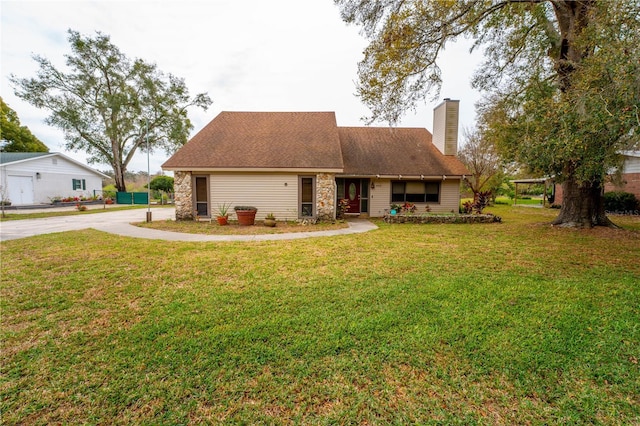 view of front facade featuring stone siding, roof with shingles, a chimney, and a front yard