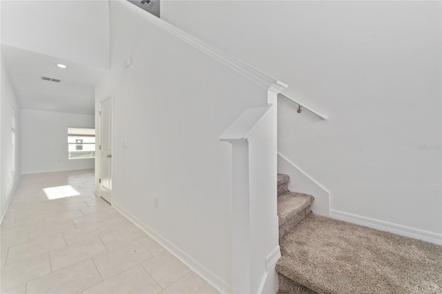 stairway with visible vents, baseboards, and tile patterned flooring