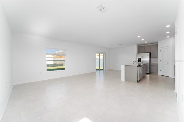 unfurnished living room with recessed lighting, visible vents, and baseboards