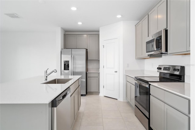 kitchen featuring visible vents, gray cabinetry, a sink, recessed lighting, and stainless steel appliances