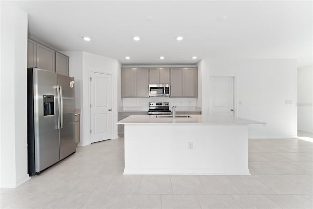 kitchen featuring a sink, stainless steel appliances, gray cabinetry, and light countertops