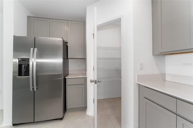 kitchen featuring light countertops, gray cabinets, and stainless steel refrigerator with ice dispenser