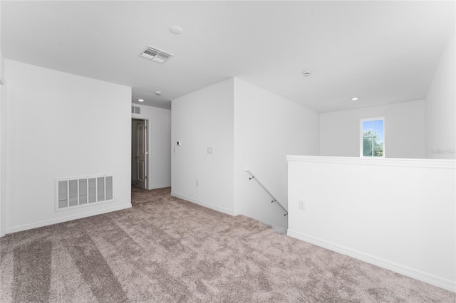 spare room with visible vents, baseboards, and carpet flooring