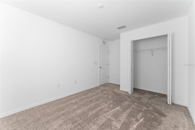 unfurnished bedroom featuring a closet, baseboards, visible vents, and carpet floors