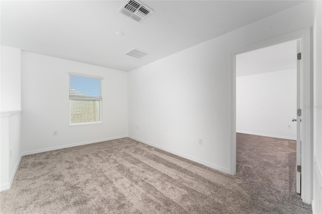 unfurnished room with baseboards, visible vents, and carpet floors