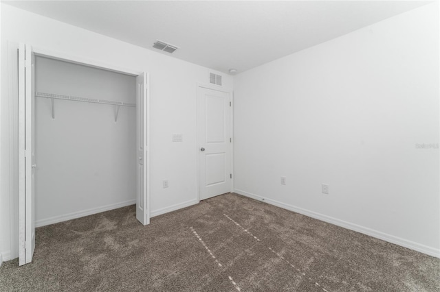 unfurnished bedroom featuring a closet, visible vents, carpet flooring, and baseboards