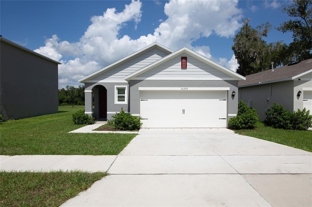 single story home with a front lawn, a garage, and driveway