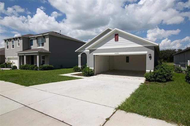 view of front of house featuring stucco siding, driveway, an attached garage, and a front lawn