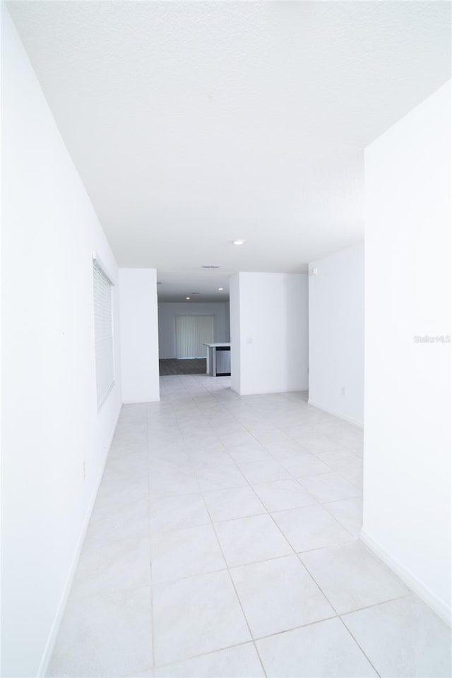 spare room with light tile patterned floors and baseboards