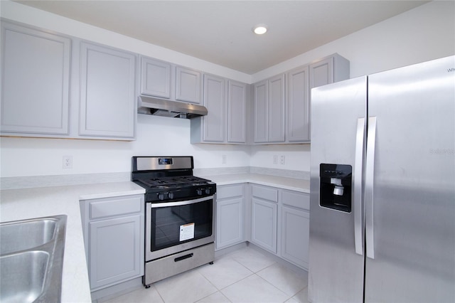 kitchen featuring under cabinet range hood, light countertops, gray cabinets, appliances with stainless steel finishes, and a sink