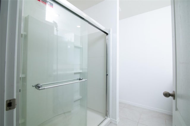 bathroom featuring tile patterned flooring, baseboards, and a stall shower