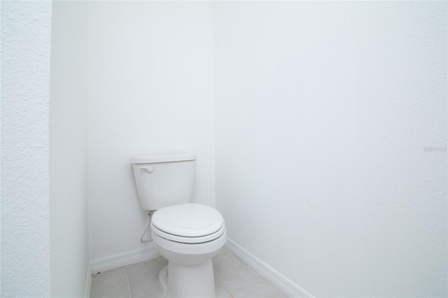 bathroom with tile patterned floors, toilet, and baseboards