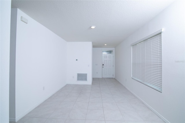 empty room with recessed lighting, visible vents, baseboards, and a textured ceiling