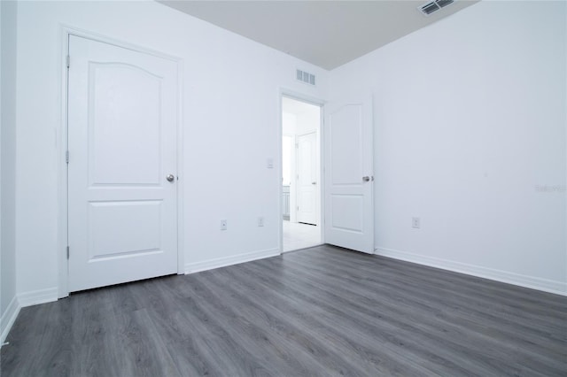 unfurnished bedroom with visible vents, baseboards, and dark wood-style flooring