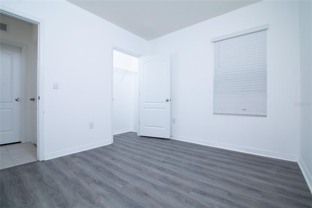 spare room featuring visible vents, baseboards, and wood finished floors