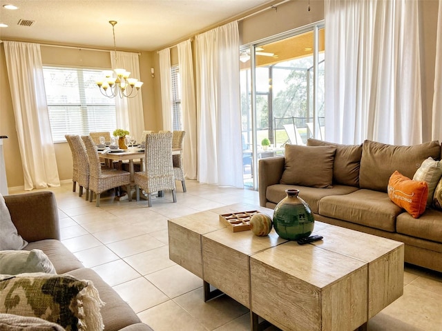 living area with visible vents, a notable chandelier, a healthy amount of sunlight, and light tile patterned flooring