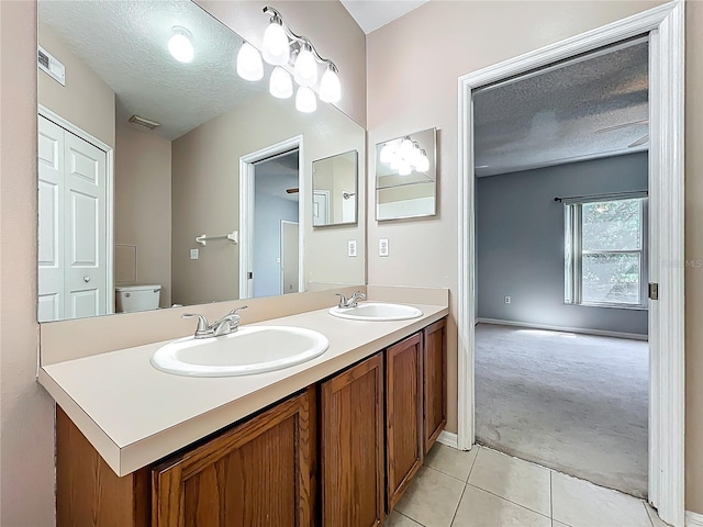 full bathroom featuring a sink, visible vents, a textured ceiling, and tile patterned flooring