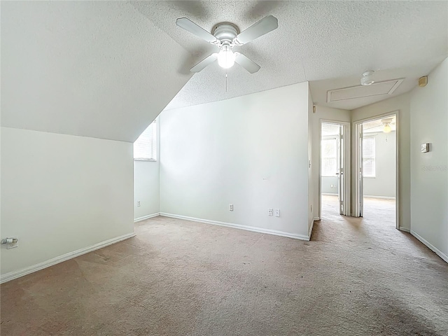 additional living space with carpet floors, a textured ceiling, and ceiling fan