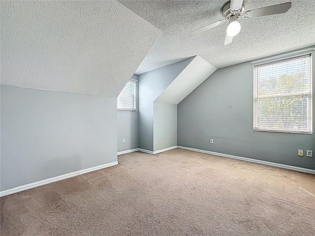 bonus room featuring baseboards, a textured ceiling, ceiling fan, and carpet flooring