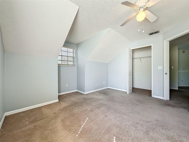 additional living space with visible vents, baseboards, lofted ceiling, a textured ceiling, and a ceiling fan