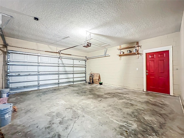 garage featuring a garage door opener and concrete block wall