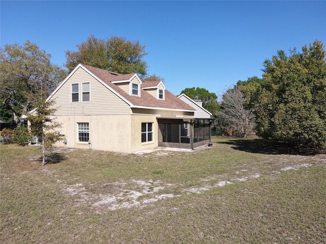 rear view of property with roof with shingles, a yard, a sunroom, and stucco siding