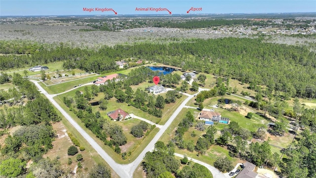 birds eye view of property featuring a forest view and a water view