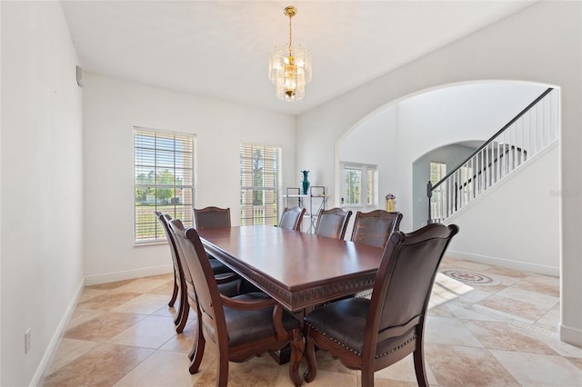 dining area with arched walkways, stairway, an inviting chandelier, and baseboards