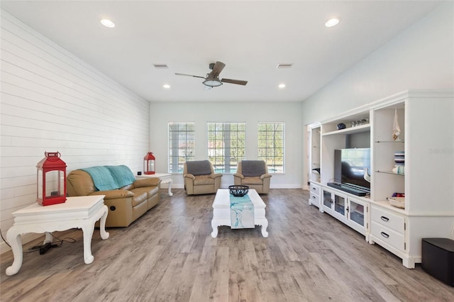 living area with a ceiling fan, light wood-style floors, and visible vents