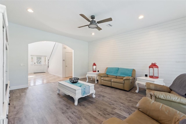 living room with visible vents, a ceiling fan, recessed lighting, arched walkways, and light wood finished floors