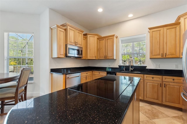 kitchen featuring dark stone countertops, light tile patterned flooring, recessed lighting, a sink, and stainless steel appliances