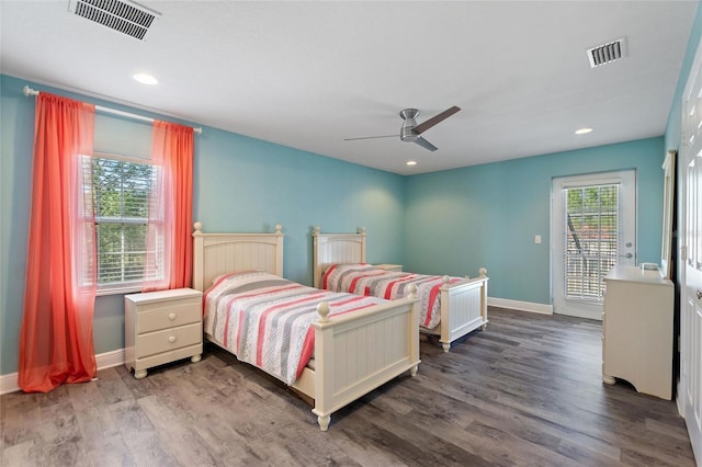 bedroom with visible vents, multiple windows, and wood finished floors