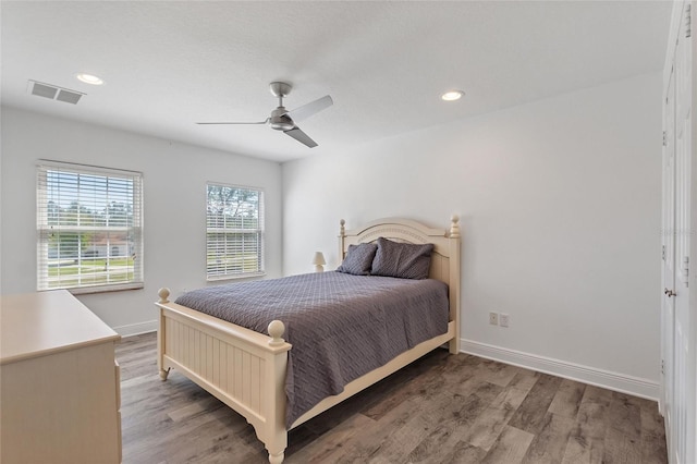 bedroom with recessed lighting, visible vents, baseboards, and wood finished floors